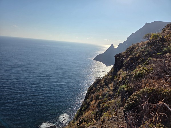 Dramatic silhouette of the Anaga cliffs with the Atlantic shining along the Punta del Hidalgo coast.