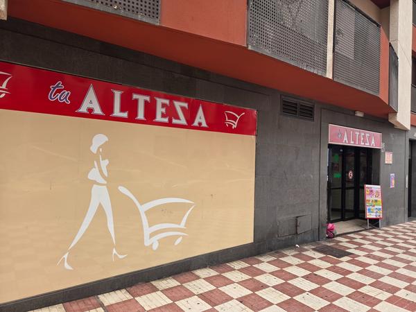 Entrance of Supermarket Alteza in Adeje with signage and shopping cart silhouette.