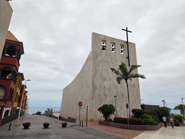 Modern concrete church building with a cross and bells near the coast of Adeje.