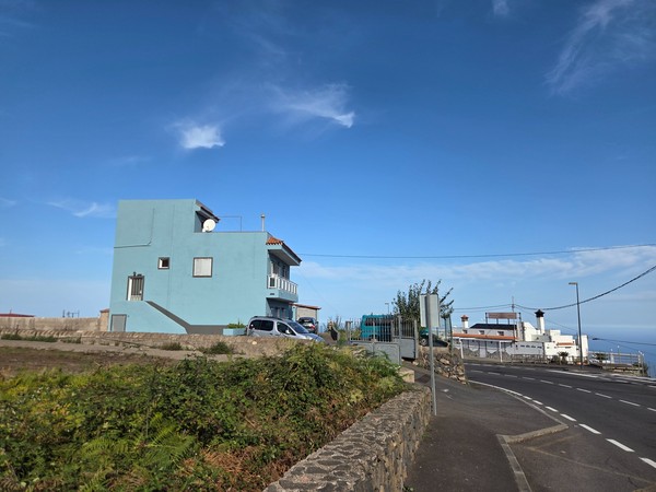 Casas aisladas de color azul y blanco en la parte alta de Aguamansa con horizonte abierto.
