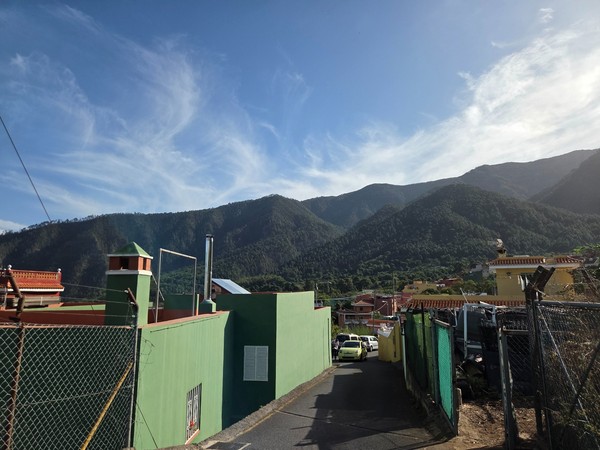 Conjunto de viviendas y tejados frente a las laderas boscosas del valle de Aguamansa.