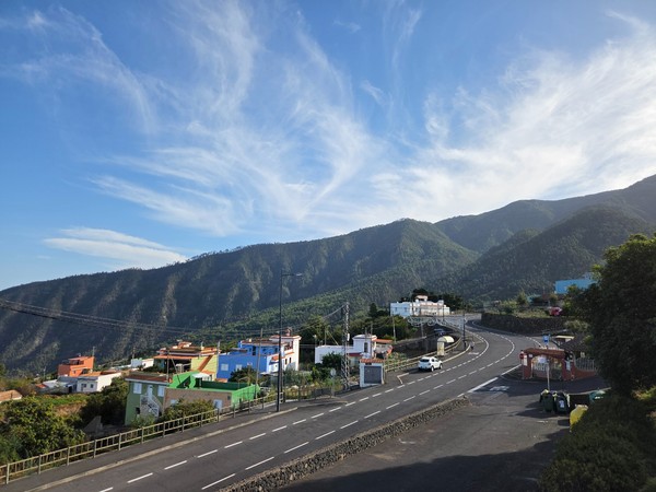 Cordal montañoso y pinar canario que rodean Aguamansa con nubes altas y luz de tarde.