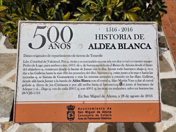 Commemorative board marking 500 years of Aldea Blanca history with text about early land distribution in Tenerife.