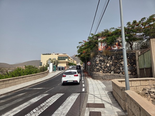 Village road in Aldea Blanca with traffic calming, tree shade and garden walls.