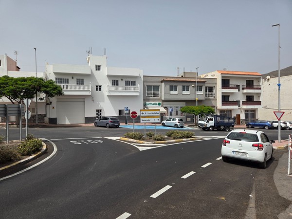 Roundabout by the pharmacy in Aldea Blanca with STOP markings and parking bays.