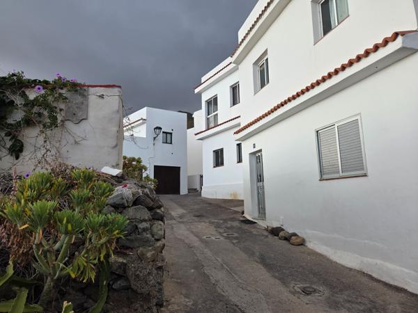 Narrow uphill street between white houses in the village of Almáciga.