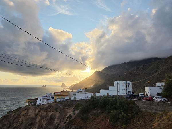 Almáciga village illuminated by early morning light with silhouettes of the Roques de Anaga.