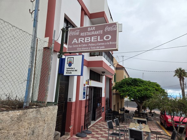 Facade of Bar Restaurante Arbelo in Arico, advertising grilled meats and local wine.