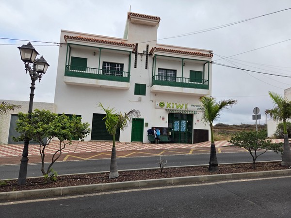 Kiwi Mercado Verde storefront in Arico with green signage and a bench outside.