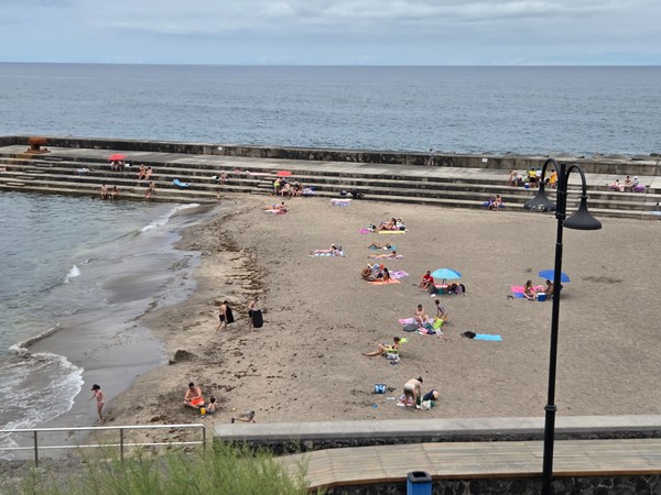 Black-sand beach of Bajamar with gentle surf and stepped breakwater.