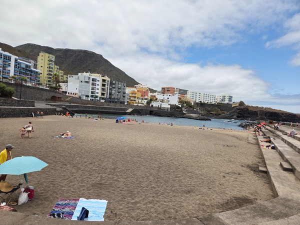 View across the sandy cove of Bajamar towards the breakwater and family area.