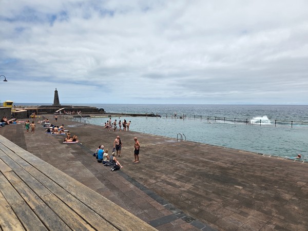 Large seawater pool at Bajamar as waves break behind the protective barrier.
