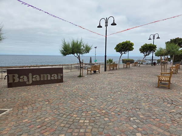 Open promenade in Bajamar with the name sculpture and ocean backdrop.