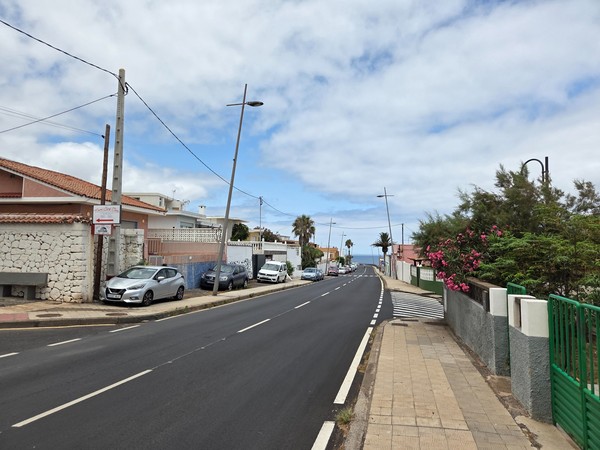 Main avenue in Bajamar leading towards the ocean with sidewalks and parking.