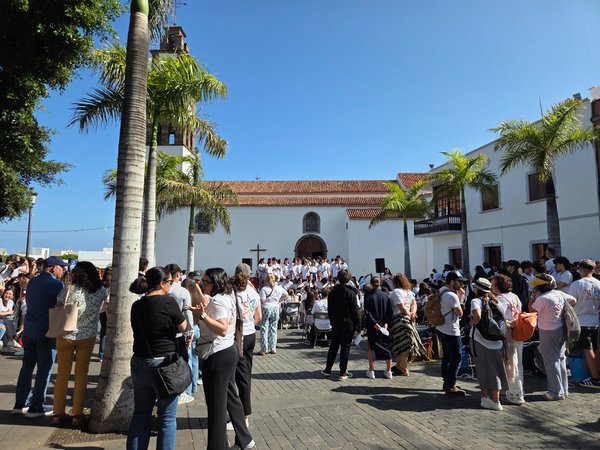 Local choir and spectators during a community celebration in front of the church.