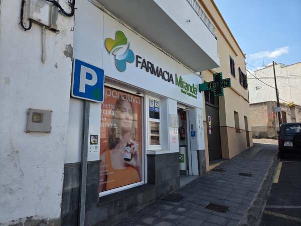 Modern pharmacy with digital sign and street-facing window display.