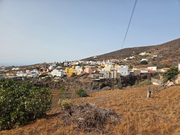 Panoramic view over Barranco Hondo with white and pastel houses spread across volcanic slopes.