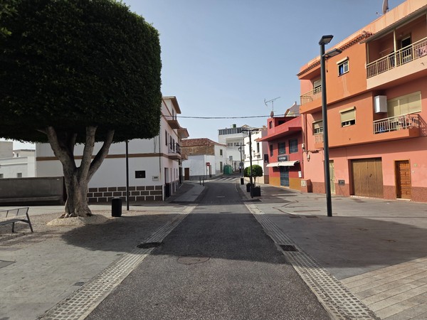 Steep lane curving uphill between colorful houses in Barranco Hondo.