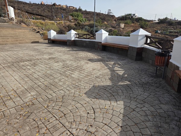 Small viewpoint plaza with stone paving and benches overlooking the hillside above Barranco Hondo.