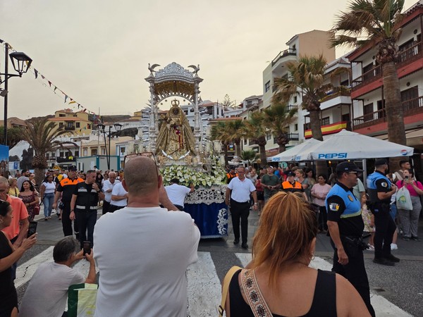 Close view of the silver carriage with the statue of the Virgen de la Candelaria surrounded by attendants.