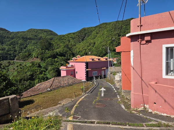 Cluster of pink and terracotta village homes nestled into the steep Anaga hillside.