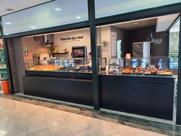 Counter of Rincón del Pan bakery and coffee shop displaying fresh pastries inside the mall.