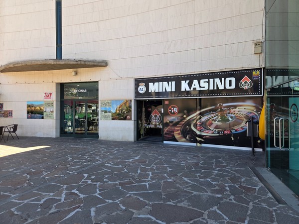 Entrance of Mini Kasino with roulette artwork beside the offices door on the exterior plaza.