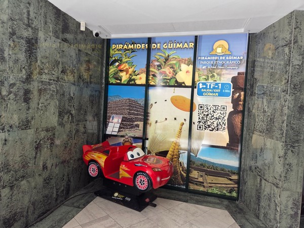 Promotional corner for Pirámides de Güímar with photos and a red kids car ride.