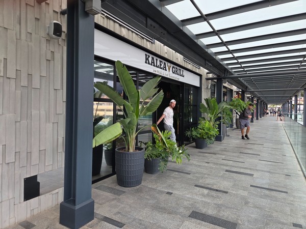 Kalea Grill entrance framed by tropical planters along the upper gallery.