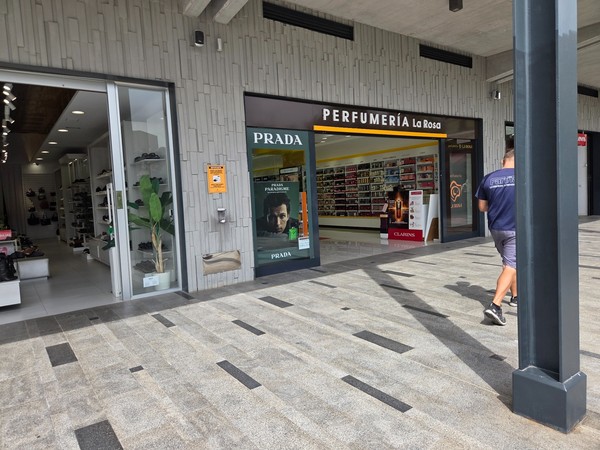 Perfumería La Rosa showcasing Prada fragrances and a wide cosmetics wall.