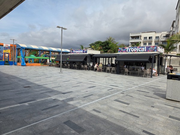 Tropical bar with shaded outdoor seating next to the play area.
