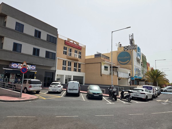 Commercial buildings and parked cars around central La Chafira.