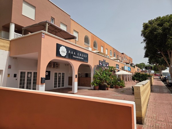 Arcade of shops and offices including AAA Group tax services in La Chafira.