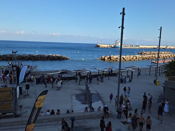 View from above across the Los Charcos promenade and breakwaters with people enjoying the waterfront.