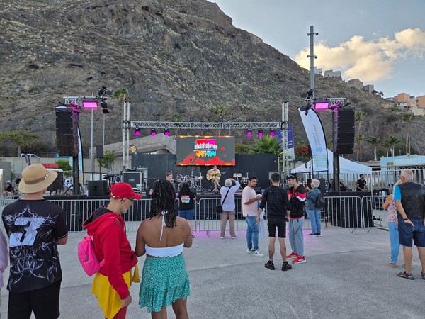 Open-air concert stage set against the rocky hillside near Los Charcos.