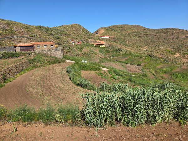 View of Chinamada's terraced landscape with farmhouses and cultivated plots on sloping hillsides.