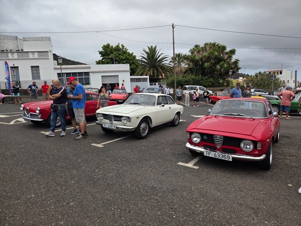 Close view of three vintage Alfa Romeos parked front-on, highlighting chrome grilles, classic badges and period headlights.