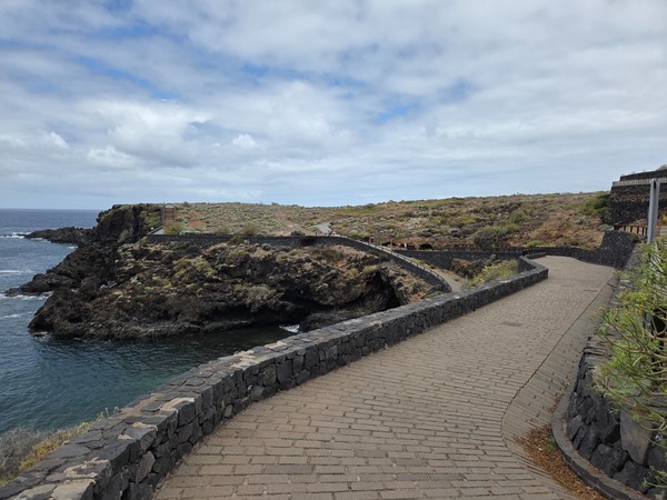 S-shaped walkway with low lava-stone walls overlooking the rugged shoreline in north Tenerife.