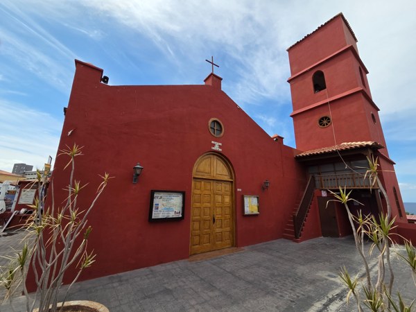 Parish church of San Eugenio with red façade and bell tower in Costa Adeje.