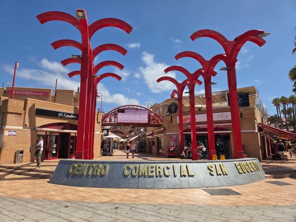 Red palm sculptures at the entrance to Centro Comercial San Eugenio.