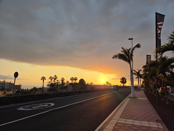 Tropical sunset over palm-lined road in Costa Adeje.