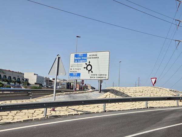 TF-1 roundabout direction sign pointing to Acorán, Costanera, Costa Caricia, Boca Cangrejo, Radazul and Candelaria in Tenerife.