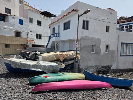 Colorful kayaks and fishing boats on the black beach
