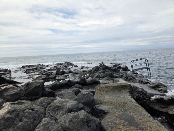 Volcanic rock pools filled with clear seawater beside the open Atlantic at El Marquéz.