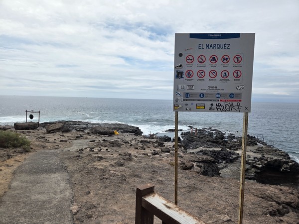 Official El Marquéz sign listing beach rules at the entrance to the rocky platform.