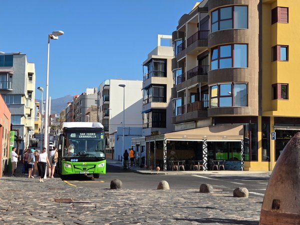 Green TITSA bus route 408 loading passengers for San Isidro and Granadilla on the seafront road.