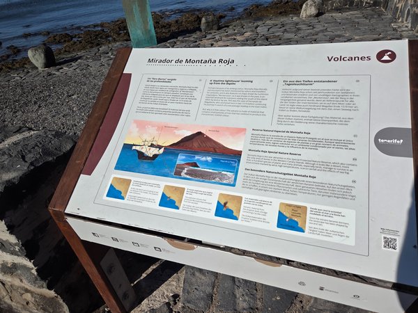 Multilingual display explaining the geology and natural reserve of Montaña Roja at the Mirador viewpoint.