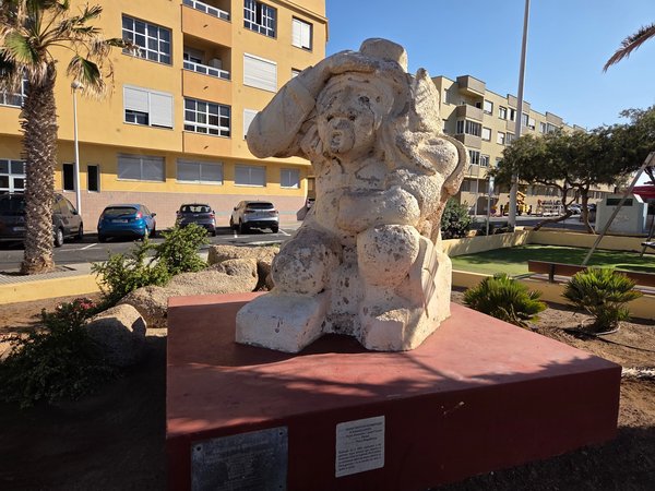 Abstract limestone monument dedicated to women fish-packers in a small plaza near the beach.