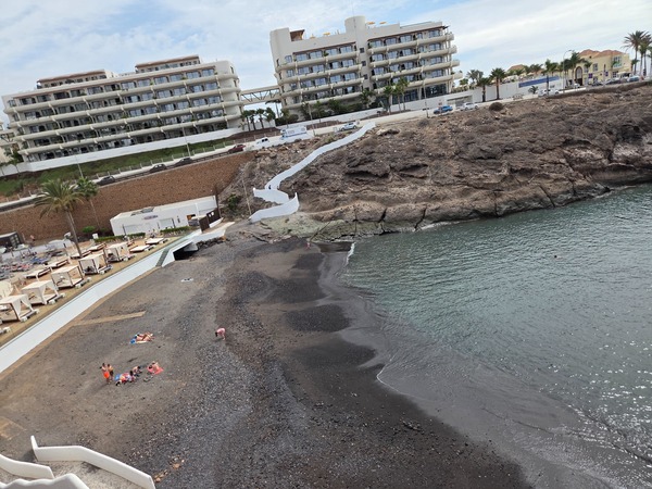 Waterline at Playa El Pinque protected by breakwater, ideal for a relaxed swim on calm days.