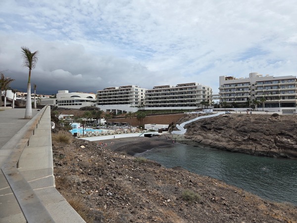 Wide view of Playa El Pinque cove with calm Atlantic water and volcanic cliffs near Playa Paraíso, Tenerife.